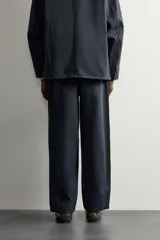 Pantalón chino regular fit confeccionado en algodón, color negro, con bolsillos frontales, bolsillos traseros de vivo con botón y cierre frontal con cremallera y botón. Colección especial Aaron Levine x ZARA.