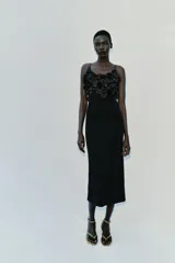Vestido midi negro de punto con tirantes finos, escote recto adornado con aplicaciones de flores tridimensionales de tela satinada y abertura en la espalda.
