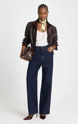 Jean de corte recto y tiro alto, confeccionado en denim azul oscuro. Presenta costuras verticales frontales que estilizan la silueta, cintura estructurada con trabillas, bolsillos funcionales y cierre frontal con botón y cremallera.