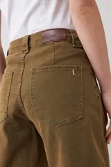 Bermuda de jean color verde oliva, corte a la rodilla, con bolsillos delanteros y traseros, y presillas para cinturón.