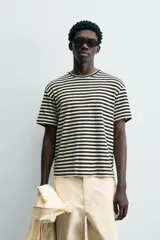 Camiseta de manga corta con cuello redondo y calce relajado, confeccionada en tejido de rayas horizontales blancas y negras.