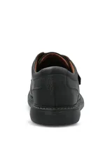 Zapato de cuero negro con textura granulada, diseño de punta redonda y ajuste mediante una tira de velcro. Cuenta con una suela de goma EVA que proporciona flexibilidad y aislamiento térmico.