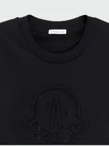 Remera de manga corta color negro, con cuello redondo y logo de la marca bordado en el pecho con detalles de cristales tono sobre tono.