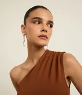 Aros medianos colgantes con baño dorado, base con detalle de hojas texturizadas y colgante de cristal transparente en forma de lágrima facetada.