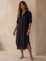 Vestido camisero midi blanco de lino, con cuello camisero, botonadura frontal completa con botones de nácar, mangas largas con tira para arremangar y abertura lateral en el bajo.