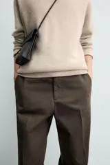 Pantalón chino de corte regular fit, confeccionado en tejido de algodón con estructura diagonal. Presenta bolsillos frontales, bolsillos traseros de vivo con botón y cierre frontal con cremallera y botón.