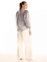 Blusa de organza translúcida con acabado satinado, mangas estilo balloon con volados en los hombros y puños elastizados. Incluye musculosa interna a tono.