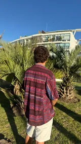 Camisa de manga corta con estampado floral en tonos borgoña, azul y blanco.