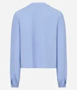 Blusa tipo bata de color celeste con mangas largas y cuello mao con lazo. Presenta detalles de bordado floral calado tipo laise en el frente y cierre parcial con botones.