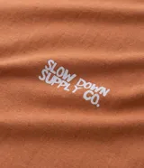 Musculosa masculina de algodón color tostado, con cuello redondo y sisas amplias. Presenta estampa pequeña en el pecho y diseño gráfico grande en la espalda, con un corte holgado y cómodo.