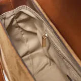 Bandolera color tostado de símil gamuza con detalles en cuero sintético marrón. Cuenta con solapa frontal con cierre magnético, logo XL en el frente, asa corta desmontable y correa larga regulable y desmontable. Incluye herrajes metálicos dorados y bolsillo interno con cierre.