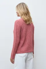 Sweater de punto color rojo melange, con cuello redondo, manga larga y detalle de bordado floral en relieve en color crudo en el frente.