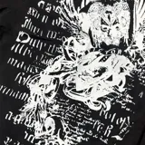 Camisa de manga corta color negro, con corte regular y cierre frontal de botones. Presenta un estampado gráfico en blanco en el lado derecho del pecho con motivos artísticos y tipografía gótica.