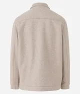 Campera pesada tipo trucker de polivelour color beige, con cuello camisero, cierre frontal por cremallera y dos bolsillos frontales con solapa en el pecho.