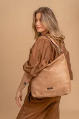 Cartera tipo bandolera de gran tamaño, confeccionada en cuero sintético con acabado desgastado. Cuenta con una asa corta fija, una correa larga regulable y extraíble, y una placa metálica con la marca en la parte frontal.