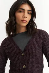 Cárdigan color borgoña de tejido de punto con textura acanalada, escote en V, cierre frontal con botones y mangas largas abullonadas.