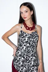 Top blanco con estampado floral negro, corte sencillo, escote abullonado, tiras finas y espalda abierta.