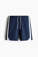 Short de baño azul marino con bandas laterales blancas, cintura elástica con cordón de ajuste blanco y dobladillo curvo.