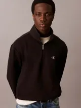 Buzo de felpa negro con cuello alto tipo mock y cierre de cremallera de un cuarto. Presenta el logo Archive de Calvin Klein bordado en el pecho, puños y bajo acanalados.
