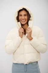 Campera puffer corta de color beige, con capucha integrada, cierre frontal y diseño acolchado.