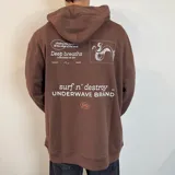 Canguro oversize color marrón con capucha y estampado gráfico en la espalda que incluye texto y un dibujo de un pulpo.