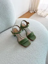 Sandalias de gamuza color verde pistacho, con tira frontal ancha, tira al tobillo con hebilla ajustable y taco cuadrado mediano.