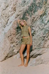 Shorts mini de tiro alto color verde militar, con detalle de botones metálicos y aplicaciones en la parte delantera.