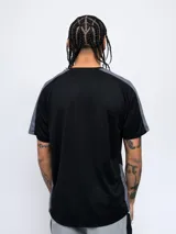 Remera deportiva Umbro de manga corta, color azul marino con detalles en azul claro en los hombros y laterales. Presenta cuello redondo y logo de la marca estampado en el pecho.