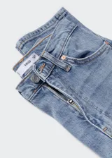 Pantalón jean de corte ajustado y tiro alto, en tono azul claro con efecto deslavado y diseño tobillero.