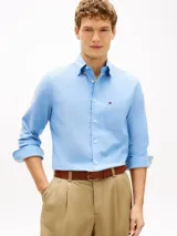 Camisa de corte regular confeccionada en algodón Oxford elástico y ligero, color celeste. Cuenta con cuello abotonado, mangas largas con puños redondeados, bolsillo de parche en el pecho con el logo bordado y bajo redondeado.