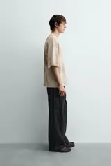 Camiseta de punto de algodón con corte relajado (relaxed fit) y cuello redondo. Presenta un estampado frontal con efecto spray en tonos marrones y beige, y un efecto lavado general.