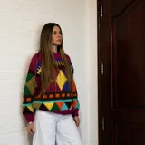 Sweater de lana merino con estampado Fair Isle en tonos azul marino, beige, naranja, verde oliva y bordó. Tiene cuello redondo y mangas largas.