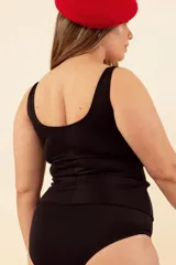 Camiseta tankini con estampado animal print en tonos marrones y beige en la parte superior y negro liso en la parte inferior. Presenta un nudo en el escote para mayor contención del busto. No incluye la parte de abajo.