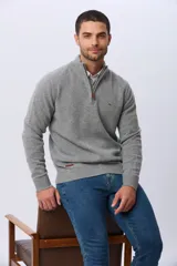 Buzo tejido de lana con cuello alto y medio cierre metálico frontal. Presenta puños y ruedo acanalados, con logo bordado en el pecho.