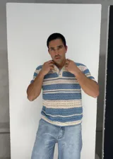 Remera tejida calada a rayas horizontales en celeste y crudo, con cuello polo y botones.