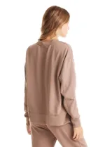 Buzo deportivo de cuello redondo, con hombros caídos, mangas largas con puño y detalle de pespuntes verticales en el frente. Presenta un diseño holgado con tajos laterales en el ruedo.