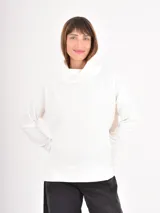 Polera de manga larga en color negro, confeccionada en tejido de punto con textura acanalada fina. Presenta un cuello alto tipo polera, corte holgado y puños ajustados.