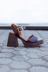 Sandalias de cuero color chocolate con plataforma y tacón cuadrado. Tira ancha sobre los dedos y tira con hebilla al tobillo.