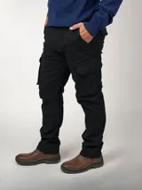 Pantalón cargo negro de corte recto, confeccionado en gabardina de algodón y lycra. Cuenta con bolsillos laterales, bolsillos plastrón con fuelle, botón y solapa a media pierna, bolsillos ojal con botón y solapa en la parte trasera, y refuerzo con doble tela en la entrepierna trasera.