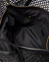 Cartera tote negra de diseño calado con trama tejida, con doble asa de hombro y detalle circular con perforaciones en el frente.