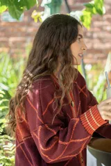 Saco tejido de punto con diseño geométrico de rombos en color azul y blanco. Presenta cuello redondo, cierre frontal con botones, mangas largas abullonadas y terminaciones acanaladas en puños y ruedo.