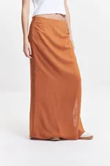 Falda larga negra de calce recto con tajo lateral alto y detalle fruncido en un lateral de la cintura.