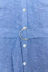 Vestido midi de cuello solapa con escote en pico y mangas tres cuartos ajustables con trabilla. Cuenta con bolsillos delanteros de plastrón, bolsillos laterales ocultos en costura, cierre frontal con botones y cinturón ajustable del mismo tejido con hebilla metálica circular.