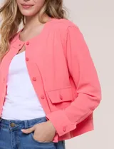 Camperita de tela liviana color beige, de silueta entallada con cuello a la base y abotonadura frontal con botones a tono. Cuenta con dos bolsillos con solapa en el frente, mangas largas con puños abotonados y largo a la cintura.