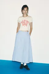 Falda midi celeste con rayas verticales finas en azul marino, de tiro alto, con pliegues en el delantero y cierre lateral con cremallera oculta.