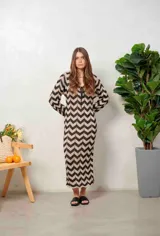 Vestido largo de lurex con diseño de patrón en zigzag en tonos tostado y marrón, escote en V con cordones para atar y mangas largas.