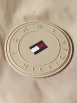Campera bomber acolchada color beige de poliéster reciclado repelente al agua, con cuello estilo béisbol, cierre de cremallera, puños y cuello de punto canalé, dos bolsillos diagonales en la cintura y detalles distintivos de Tommy Hilfiger.