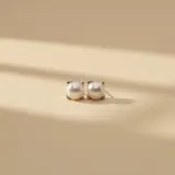 Caravanas tipo broquel elaboradas en plata 925 con perlas de río naturales de diseño clásico y minimalista.