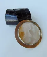 Cinturón de cuero negro con hebilla circular de nácar con engarce de alpaca.