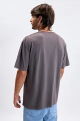 Remera de manga corta con efecto lavado, color violeta oscuro, de corte holgado y cuello redondo. Presenta un estampado pequeño con el texto 'ACTUALLY FOCUSED' centrado en el pecho.